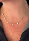 Necklace with small diamond-like pendants on a person's neck
