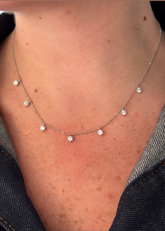 Necklace with small diamond-like pendants on a person's neck